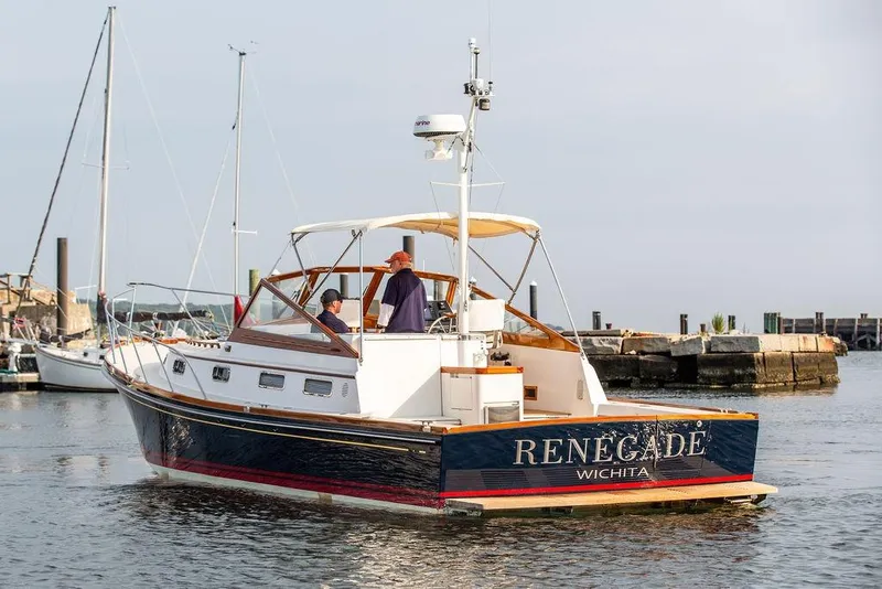 Slide: The Image of 1994 Little Harbor Express boat named "Renegade" on calm waters near a marina. - 57
