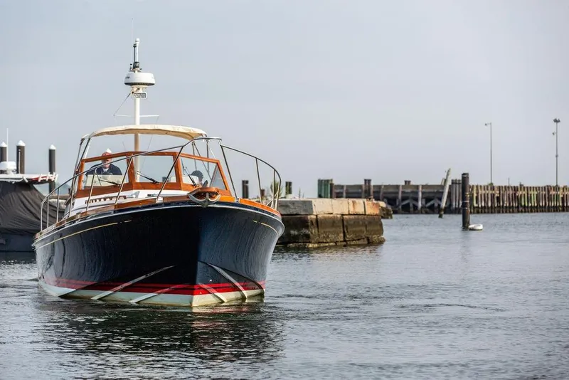 Slide: The Image of 1994 Little Harbor Express boat navigating a calm harbor near a dock. - 66