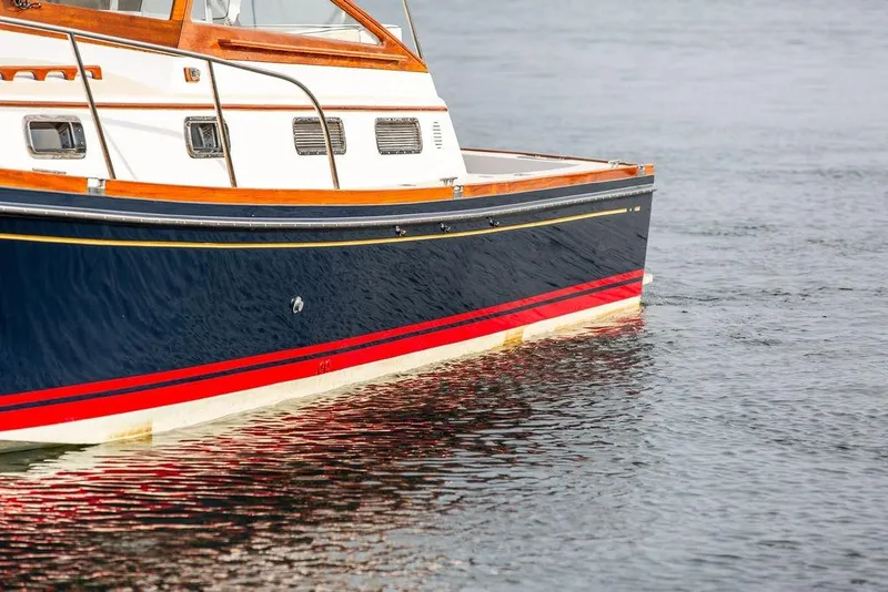 Slide: The Image of 1994 Little Harbor Express boat with navy and red hull on calm water. - 68