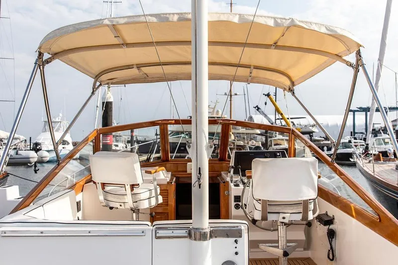 Slide: The Image of 1994 Little Harbor Express yacht interior with helm, chairs, and canopy in marina setting. - 7