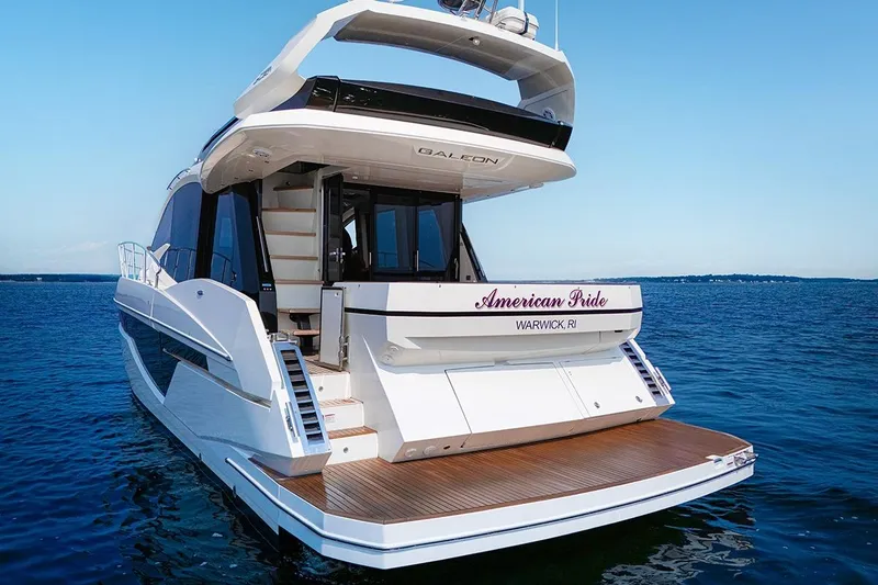 Slide: The Image of 2023 Galeon 470 Sky yacht on water, rear view, "American Pride" name visible. - 10