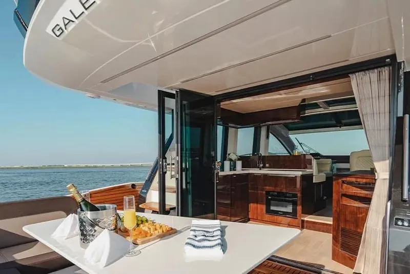 Slide: The Image of Luxury 2023 Galeon 470 Sky yacht interior with dining setup and ocean view. - 14