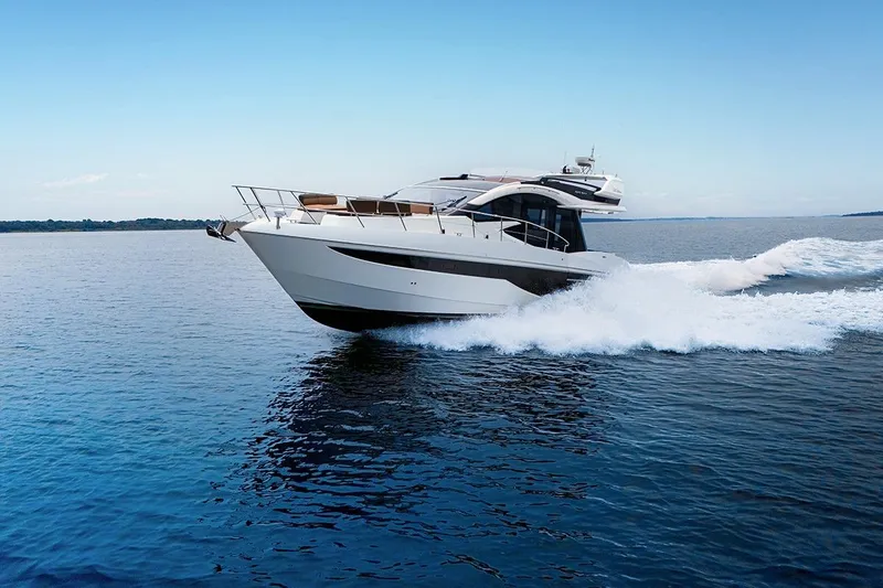 Slide: The Image of 2023 Galeon 470 Sky yacht cruising on open water under clear blue skies. - 2