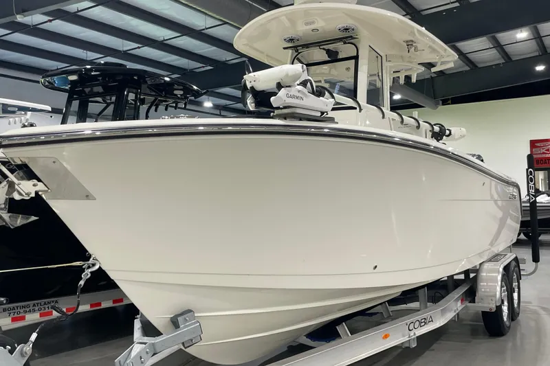 Slide: The Image of 2024 Cobia 265 Open Center Console boat on trailer in showroom. - 12