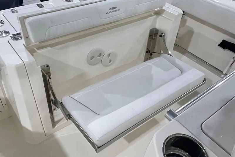 Slide: The Image of 2024 Cobia 265 Open Center Console boat with foldable seating and cup holder. - 19