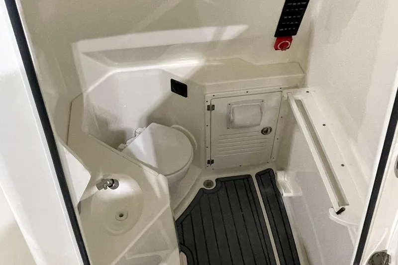 Slide: The Image of 2024 Cobia 265 Open Center Console interior with compact marine toilet and storage. - 25