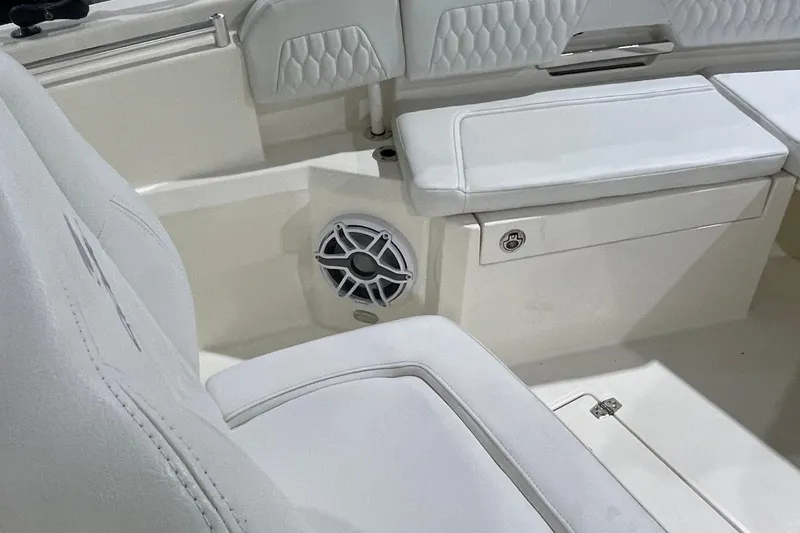 Slide: The Image of 2024 Cobia 265 Open Center Console interior with white seating and speaker detail. - 27