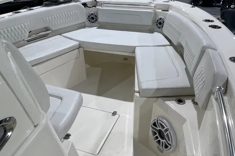 Slide: The Image of 2024 Cobia 265 Open Center Console boat interior with cushioned seating and speakers. - 28