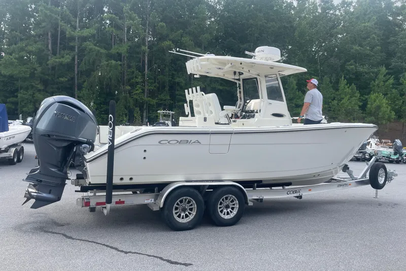 Slide: The Image of 2024 Cobia 265 Open Center Console boat on trailer, parked outdoors. - 4