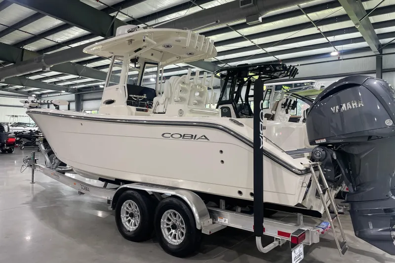 Slide: The Image of 2024 Cobia 265 Open Center Console boat on trailer in showroom. - 8
