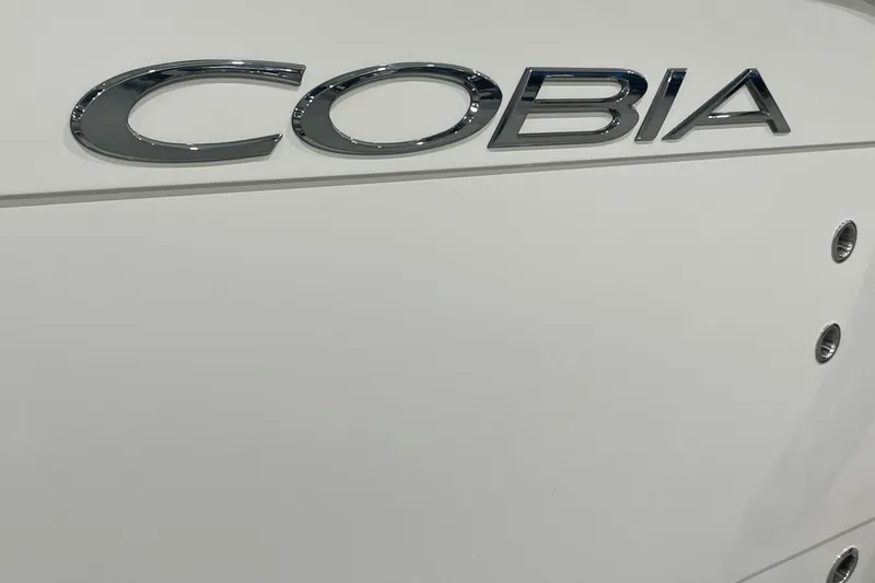 Slide: The Image of 2024 Cobia 265 Open Center Console boat logo on white hull. - 9