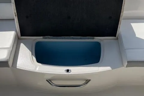Slide: The Image of 2021 Chaparral 21 SSi OB boat storage compartment with open lid, showcasing interior space. - 15
