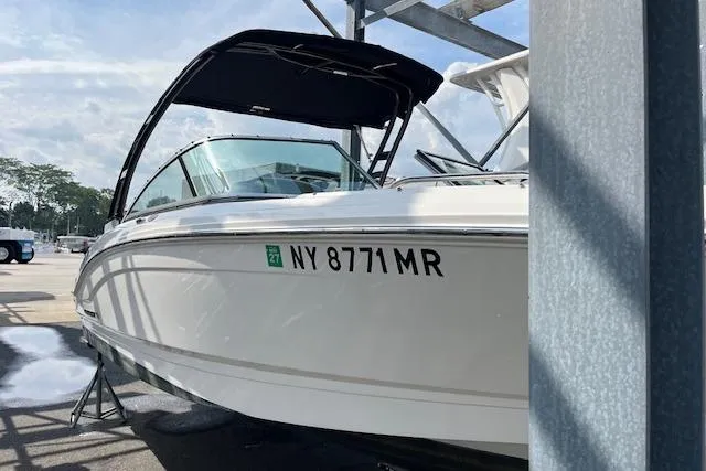 Slide: The Image of 2021 Chaparral 21 SSi OB boat with black canopy, docked in a marina. - 2