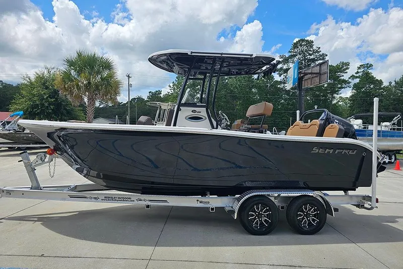 Slide: The Image of 2026 Sea Pro 225 Sandbar boat on trailer, parked outdoors under cloudy sky. - 10