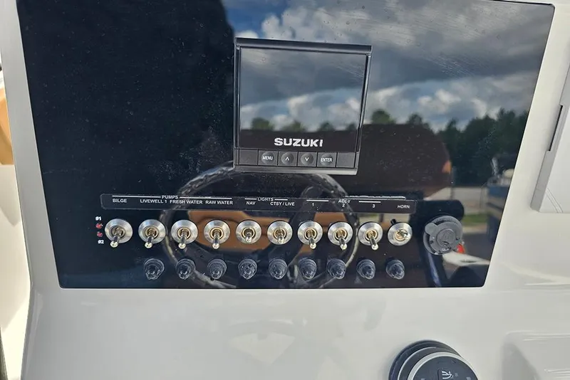Slide: The Image of Control panel of 2026 Sea Pro 225 Sandbar boat with Suzuki display and switches. - 22
