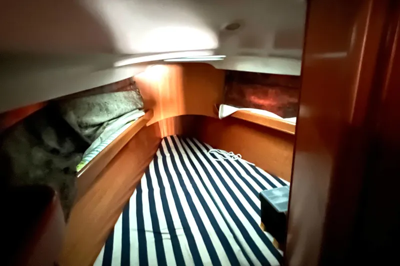 Slide: The Image of Cozy cabin interior of 2001 Beneteau First 40.7 sailboat with striped bedding. - 19