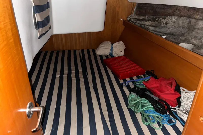 Slide: The Image of Cabin interior of 2001 Beneteau First 40.7 with striped bedding and sailing gear. - 20