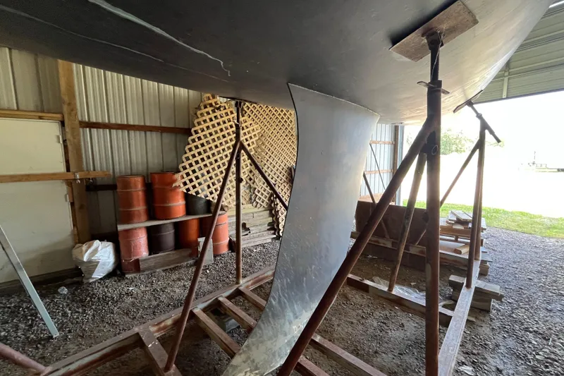 Slide: The Image of Beneteau First 40.7 sailboat keel in storage, supported by metal stands, 2001 model. - 24