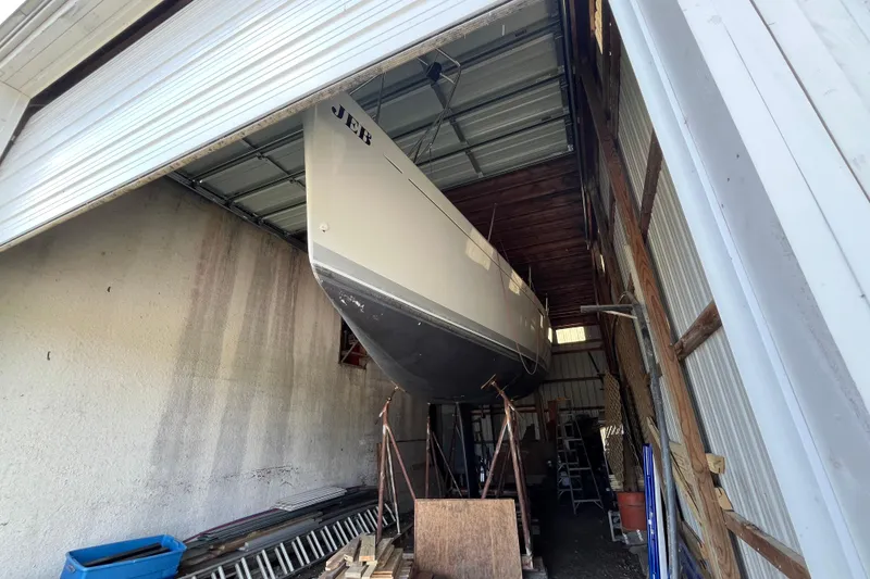 Slide: The Image of Beneteau First 40.7 sailboat from 2001 stored in a garage, viewed from below. - 28