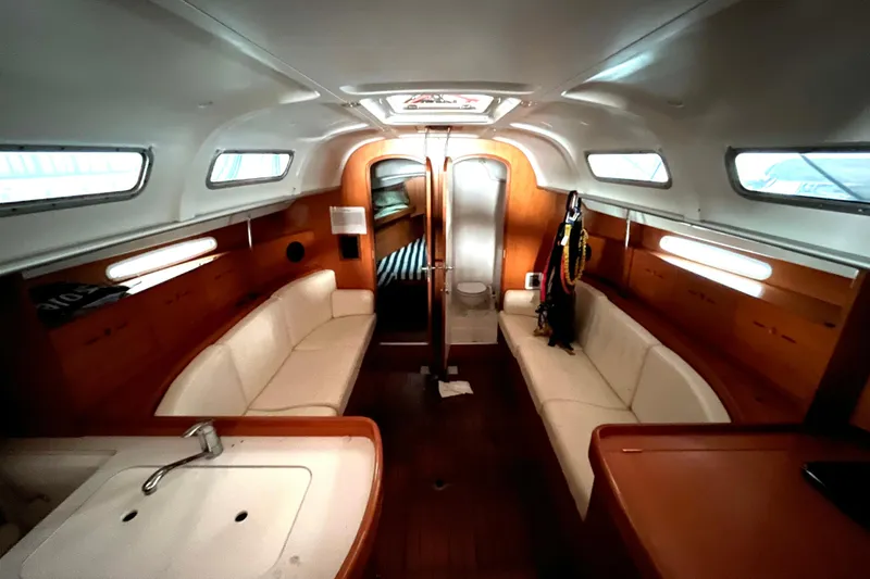 Slide: The Image of Interior of 2001 Beneteau First 40.7 yacht, featuring cozy seating and wooden finishes. - 6