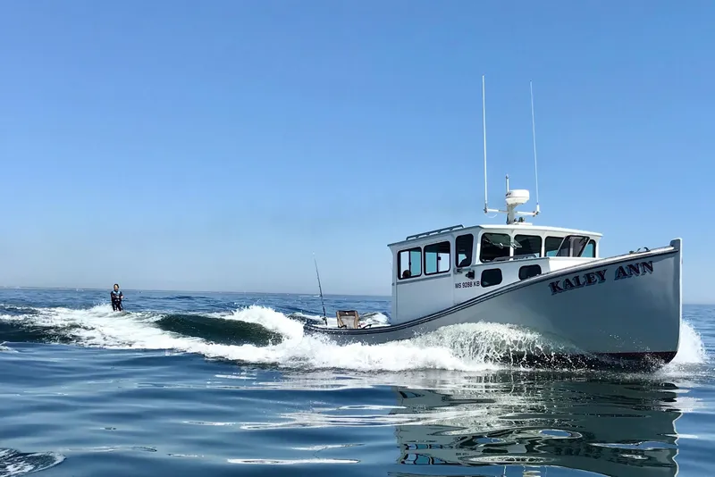 The Image of 1992 Novi 32 Downeast boat "Kaley Ann" cruising with wakeboarder on ocean. - 0