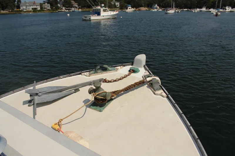 Slide: The Image of Bow of 1992 Novi 32 Downeast boat with anchor, moored in a scenic harbor. - 12