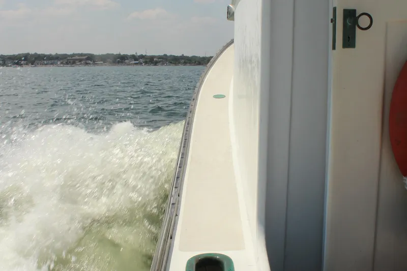 Slide: The Image of Side view of 1992 Novi 32 Downeast boat cruising on open water. - 14