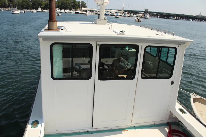 Slide: The Image of 1992 Novi 32 Downeast boat on water, featuring cabin and windows. - 16