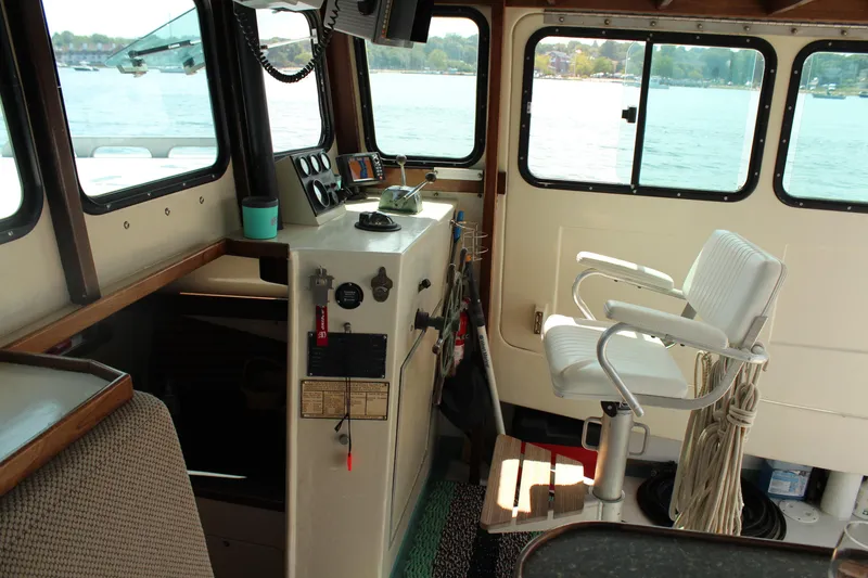 Slide: The Image of Interior of 1992 Novi 32 Downeast boat with helm and seating, overlooking water. - 19