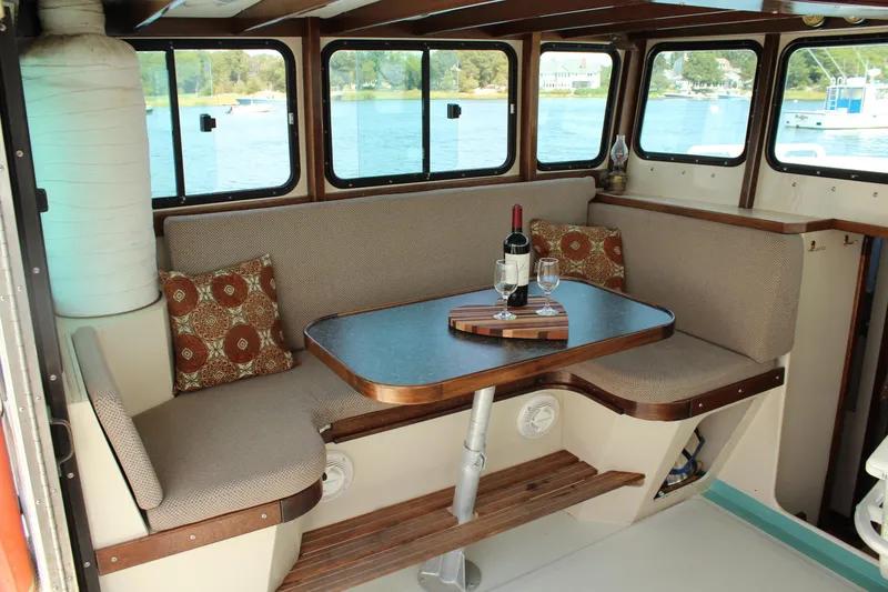 Slide: The Image of Cozy interior of 1992 Novi 32 Downeast boat with table, wine, and scenic windows. - 22