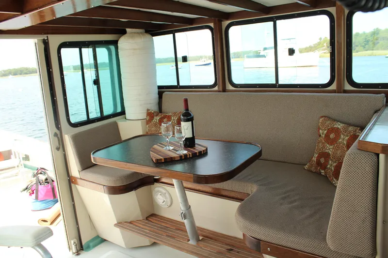 Slide: The Image of Interior of 1992 Novi 32 Downeast boat with cozy seating and wine setup. - 23