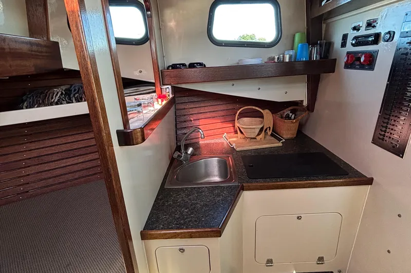 Slide: The Image of Compact kitchen area in a 1982 Stanley Greenwood/Novi 32 Downeast boat, featuring sink and countertop. - 28