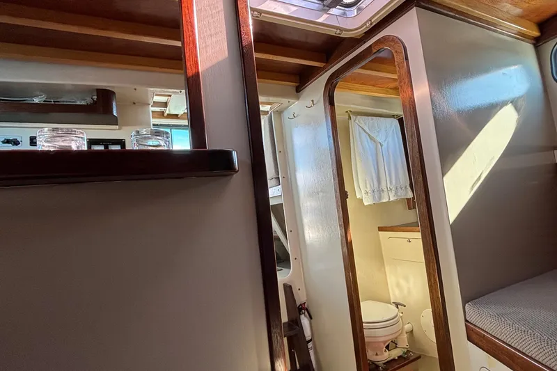 Slide: The Image of Interior of 1982 Stanley Greenwood/Novi 32 Downeast boat, featuring a compact bathroom and cozy cabin. - 31