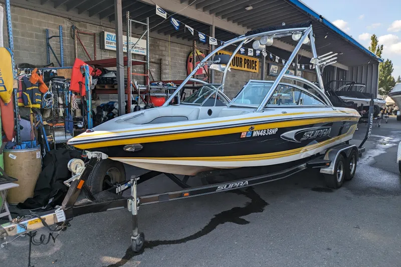 Slide: The Image of 2005 Supra Launch 21 V boat on trailer in marina setting. - 0