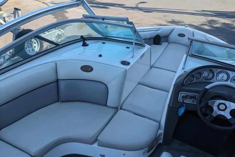 Slide: The Image of 2005 Supra Launch 21 V boat interior with white seating and dashboard controls. - 10