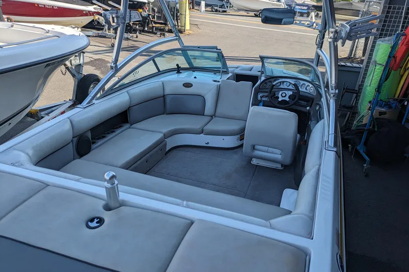 Slide: The Image of 2005 Supra Launch 21 V boat interior with seating and steering wheel, docked at marina. - 13