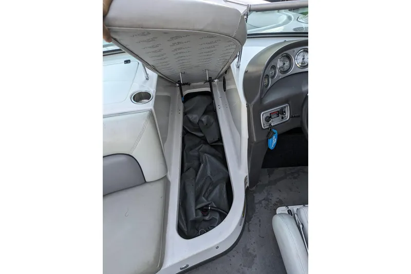Slide: The Image of 2005 Supra Launch 21 V boat interior with open storage compartment and dashboard view. - 16