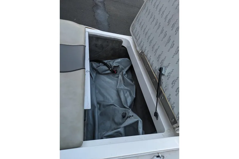 Slide: The Image of Open storage compartment in a 2005 Supra Launch 21 V boat, showing interior details. - 17