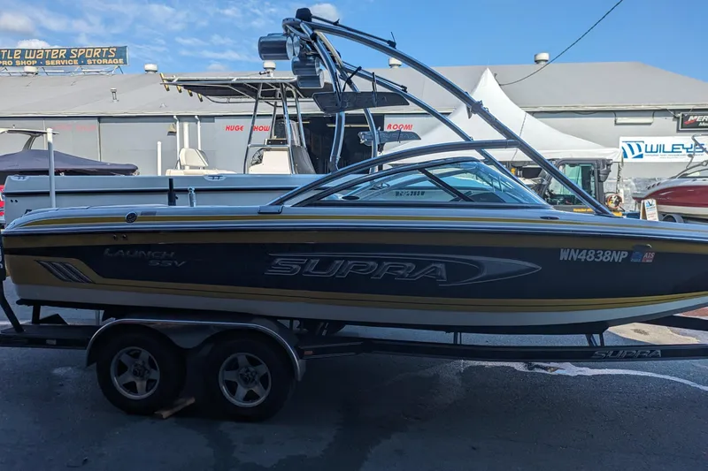 Slide: The Image of 2005 Supra Launch 21 V boat on trailer at a marine dealership. - 2