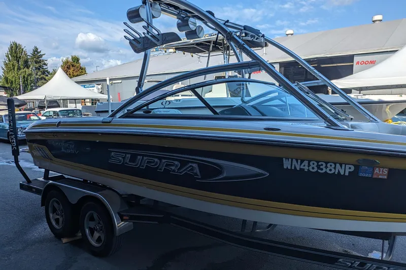 Slide: The Image of 2005 Supra Launch 21 V boat on trailer, parked outdoors under a clear sky. - 3