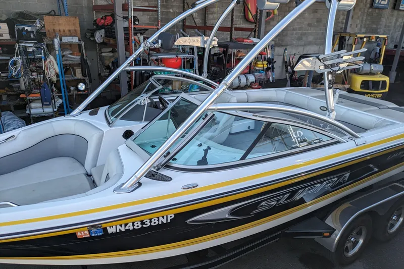 Slide: The Image of 2005 Supra Launch 21 V boat in a garage, featuring sleek design and dual consoles. - 4