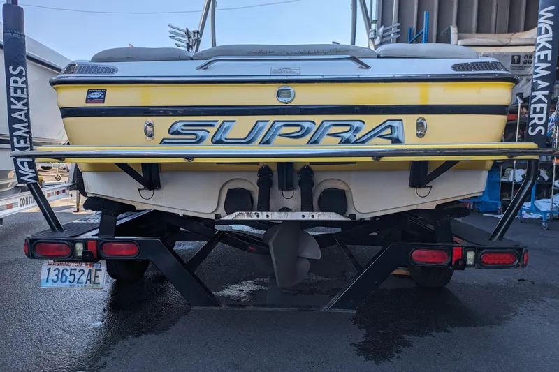 Slide: The Image of 2005 Supra Launch 21 V boat on trailer, rear view, yellow color, Wakemakers branding. - 6