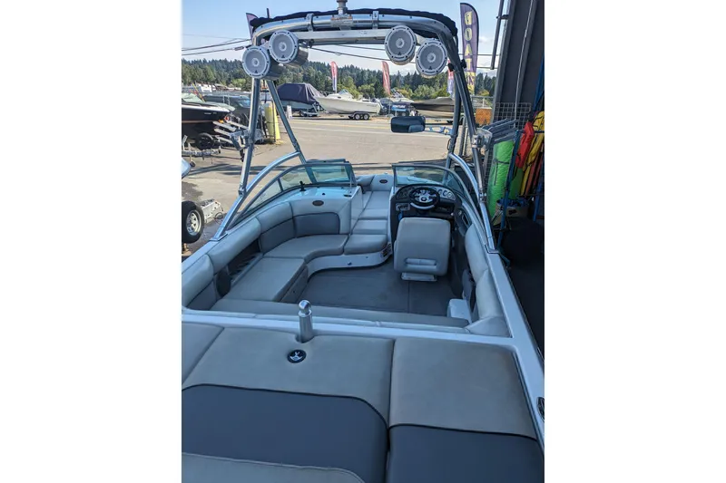 Slide: The Image of 2005 Supra Launch 21 V boat interior with seating and speakers, parked in a marina. - 7
