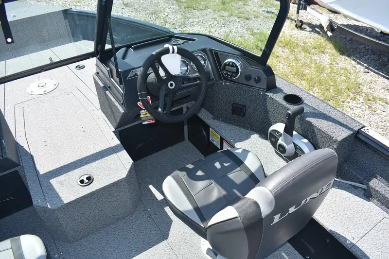 Slide: The Image of 2026 Lund 1800 Explorer Sport boat interior with steering wheel and seating. - 10