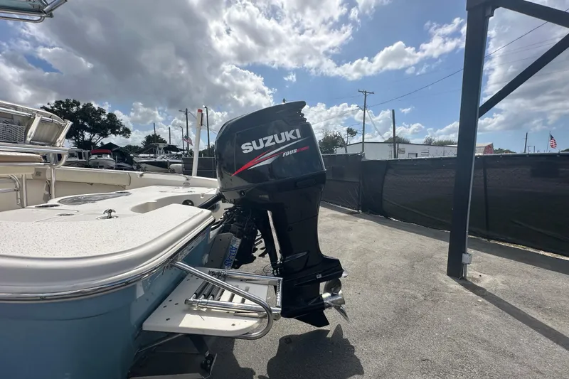 Slide: The Image of 2014 Sea Chaser 210 LX Bay Runner with Suzuki outboard motor, parked near a tree. - 10