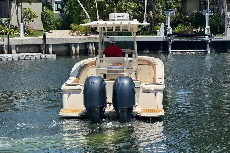 Slide: The Image of 2013 Scout 275 LXF boat with dual engines navigating a calm waterway. - 14
