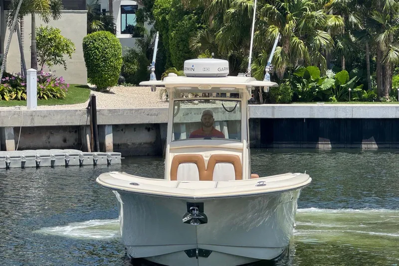 Slide: The Image of 2013 Scout 275 LXF boat navigating a canal, surrounded by lush greenery. - 16