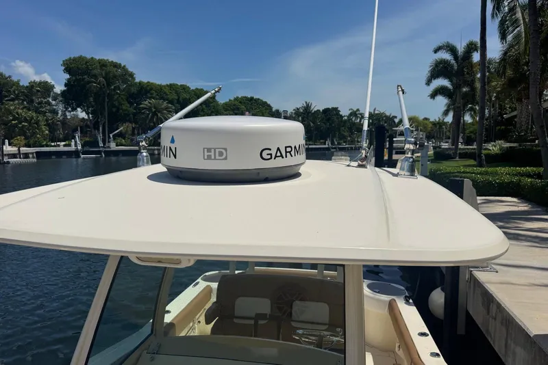 Slide: The Image of 2013 Scout 275 LXF boat with Garmin radar on top, docked by a scenic waterway. - 20
