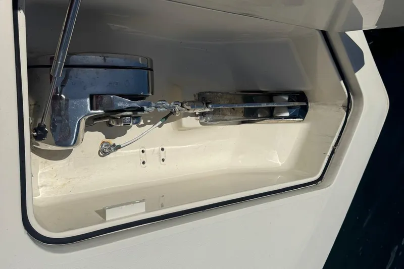Slide: The Image of Anchor compartment of 2013 Scout 275 LXF boat, featuring a winch and chain mechanism. - 21