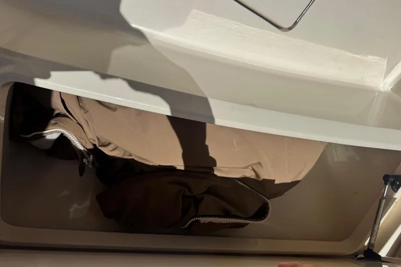 Slide: The Image of Storage compartment in a 2013 Scout 275 LXF boat with brown fabric inside. - 23